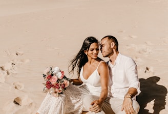 couple sitting on shore during daytime