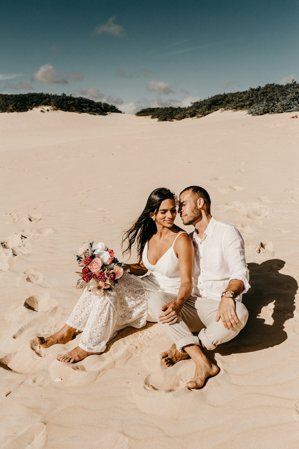 couple sitting on shore during daytime