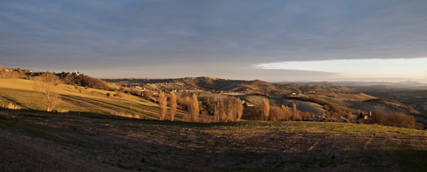 A wide landscape capturing the golden hour light over rolling hills.
