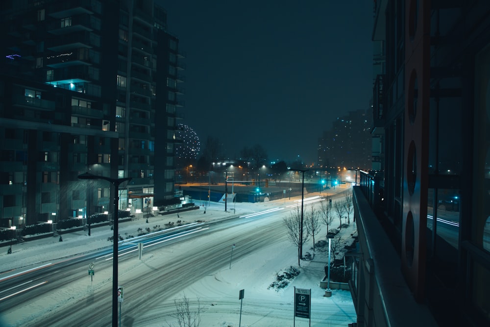 field covered with snow near high-rise buildings during night time