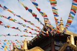 Colorful prayer flags fluttering near a peaceful temple nestled in the hills.