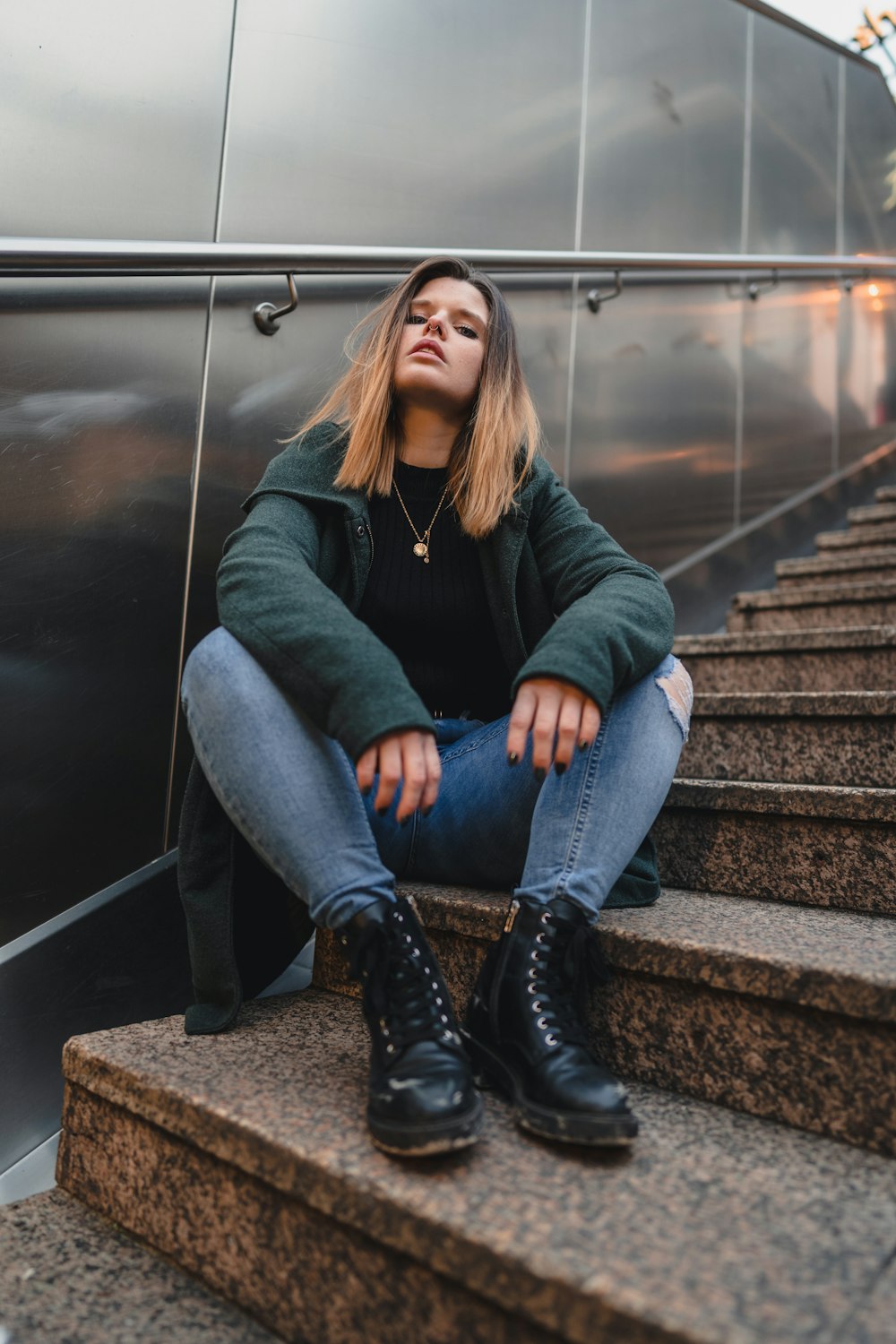 a woman sitting on the steps of an escalator