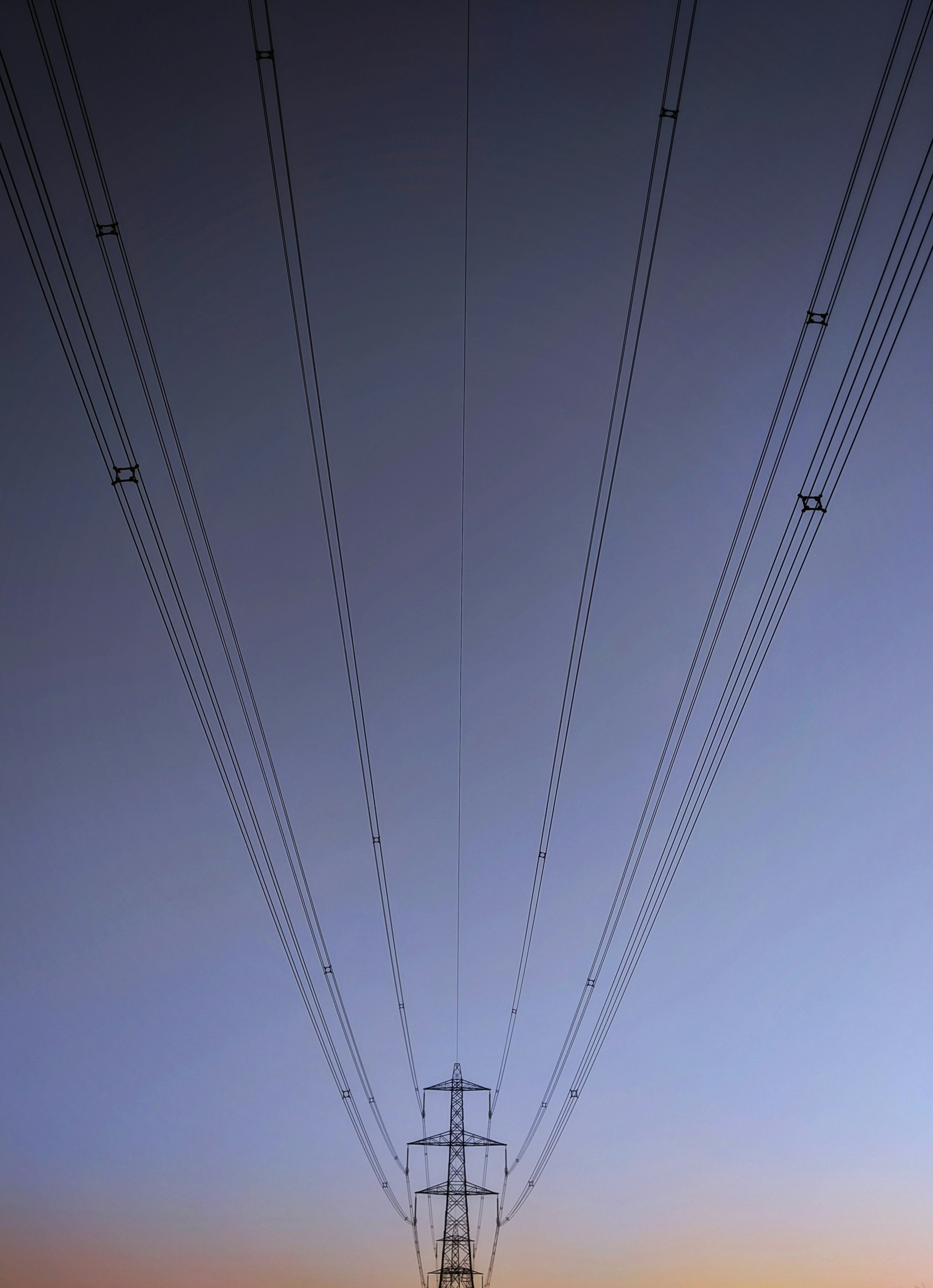 Symmetrical reflections of a pylon on a dusk backdrop 