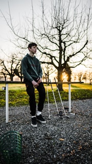 man standing beside railing and golf clubs