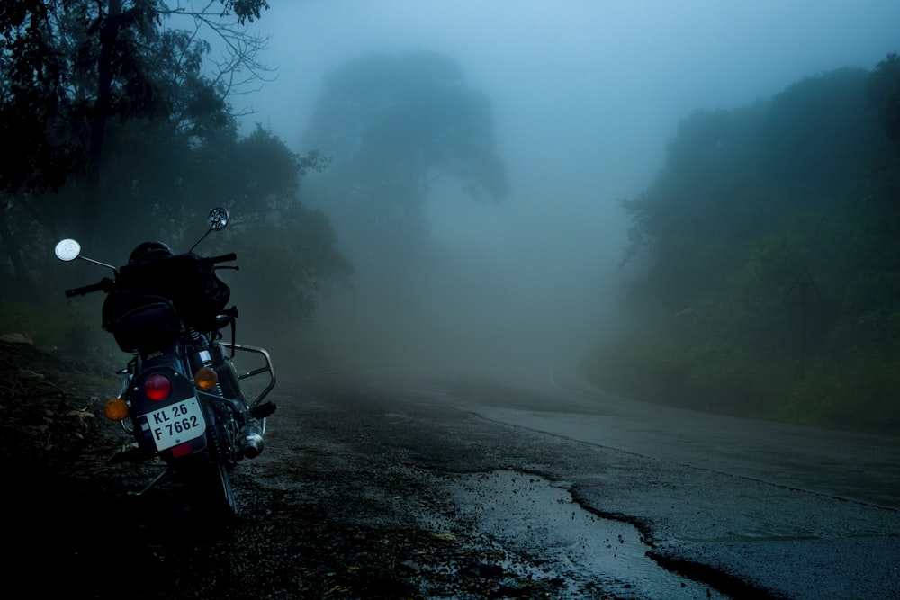 Fotografía de enfoque selectivo de motocicleta estacionada al lado de la carretera