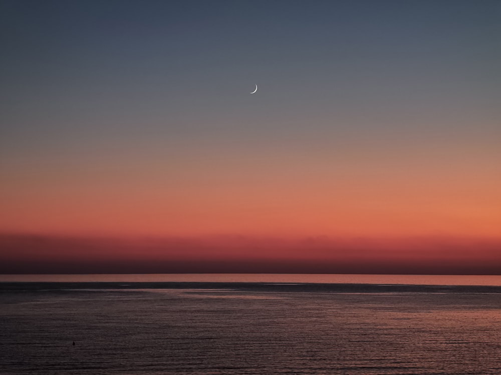 landscape photography of blue sea under an orange and blue sky