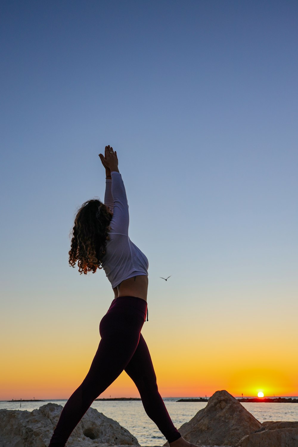 woman in white long-sleeved crop top and black pants outfit by body of water