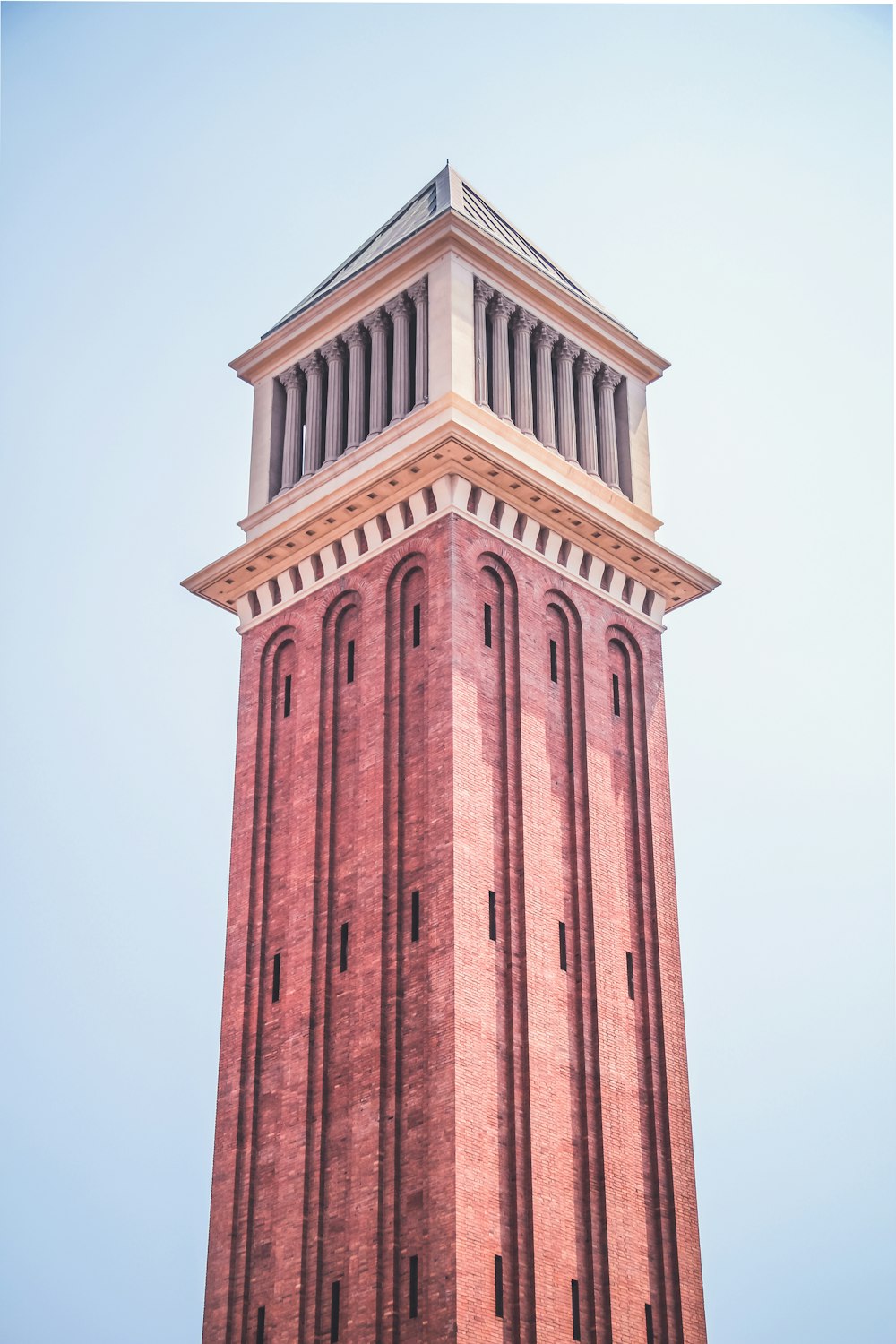 low-angle photography of brown tower under a calm blue sky