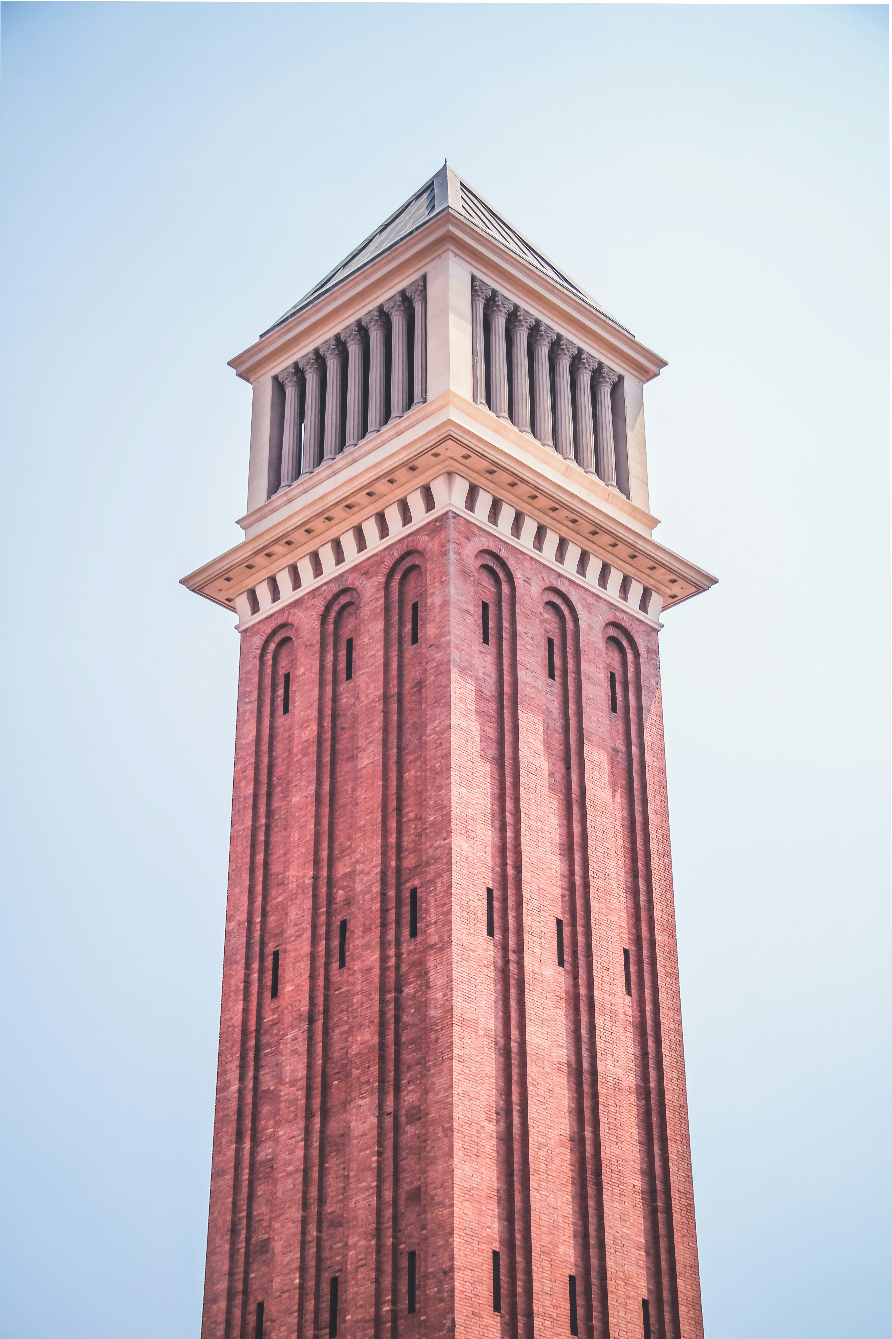 low-angle photography of brown tower under a calm blue sky