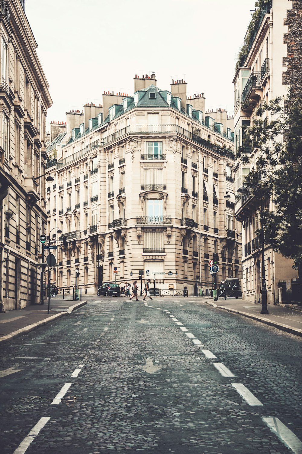 3 person crossing road by building