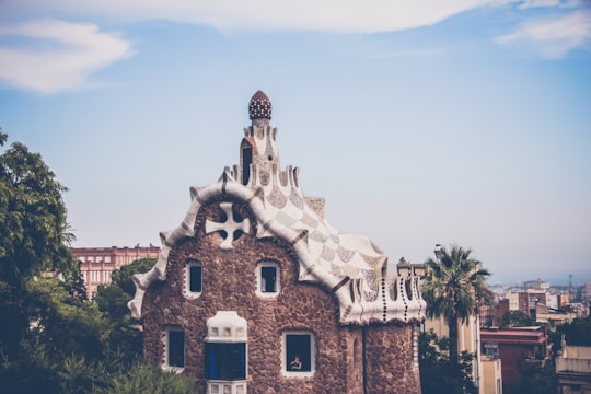 white and brown house under white sky in Park Güell Spain