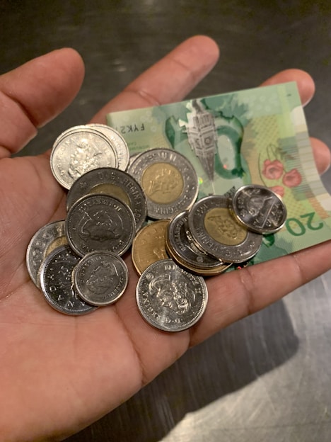 Hand holding euro coins and a €20 bill to show the currency travelers will use throughout Italy