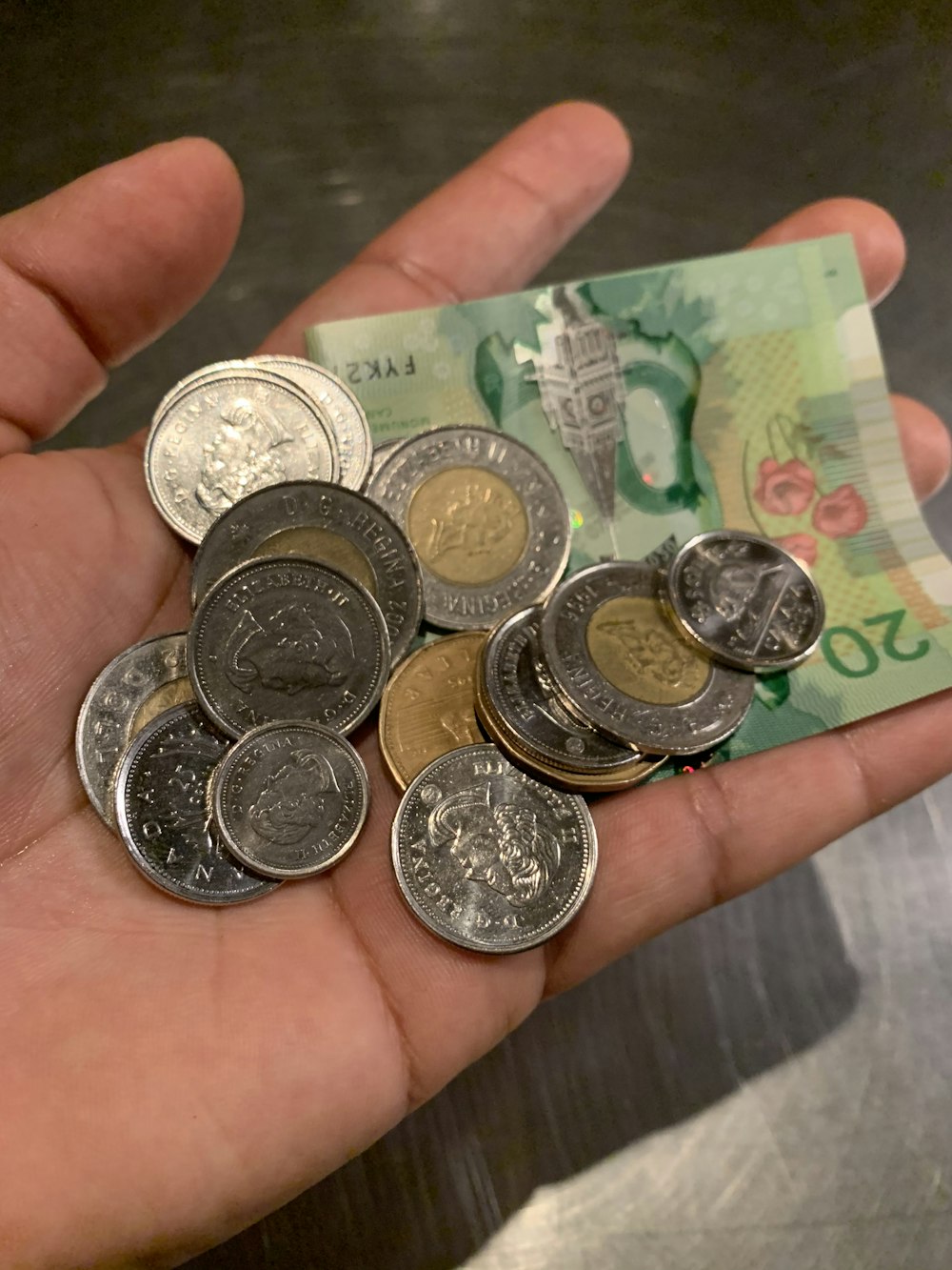 two-toned coins with banknote on hand