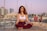 meditating woman in white sports bra and red yoga pants outfit