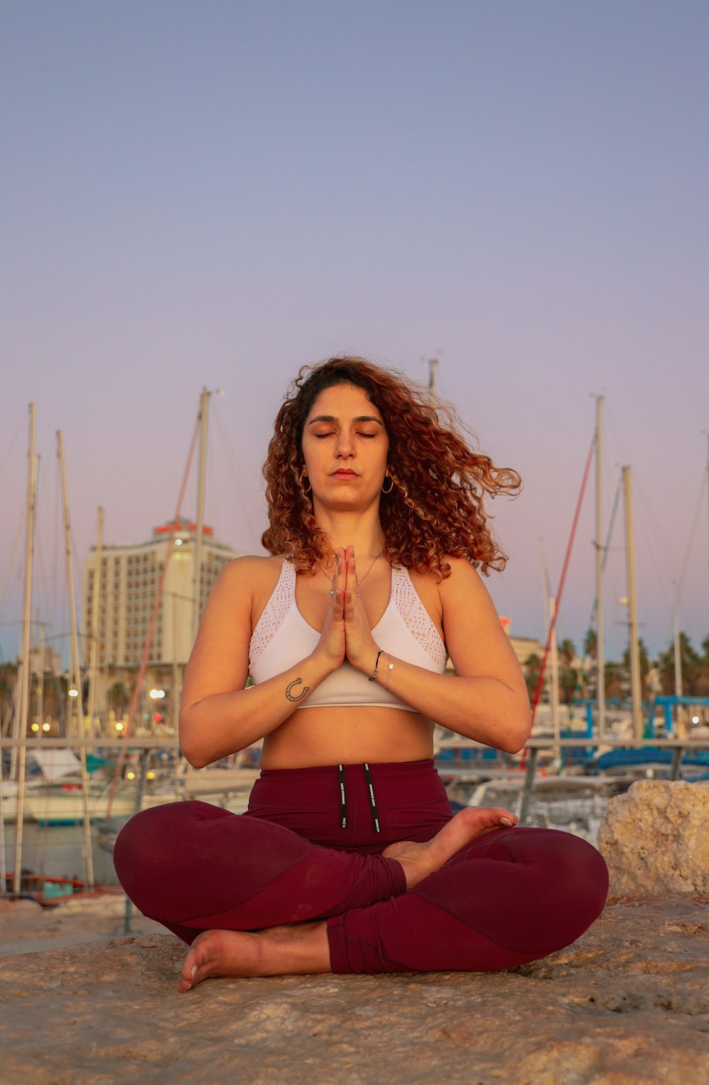 meditating woman in white crop top with palms together