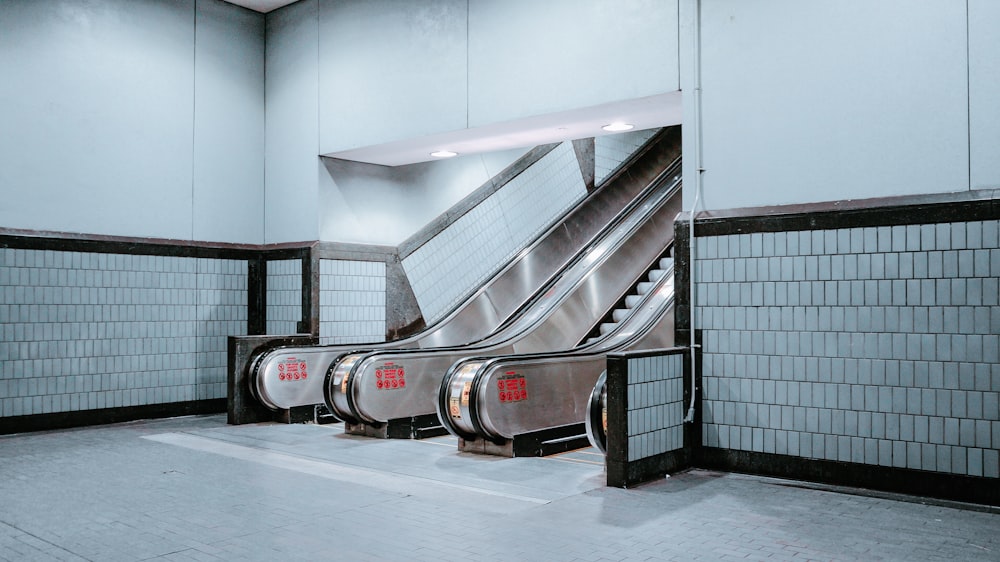 stainless steel and black escalator inside building near pathway