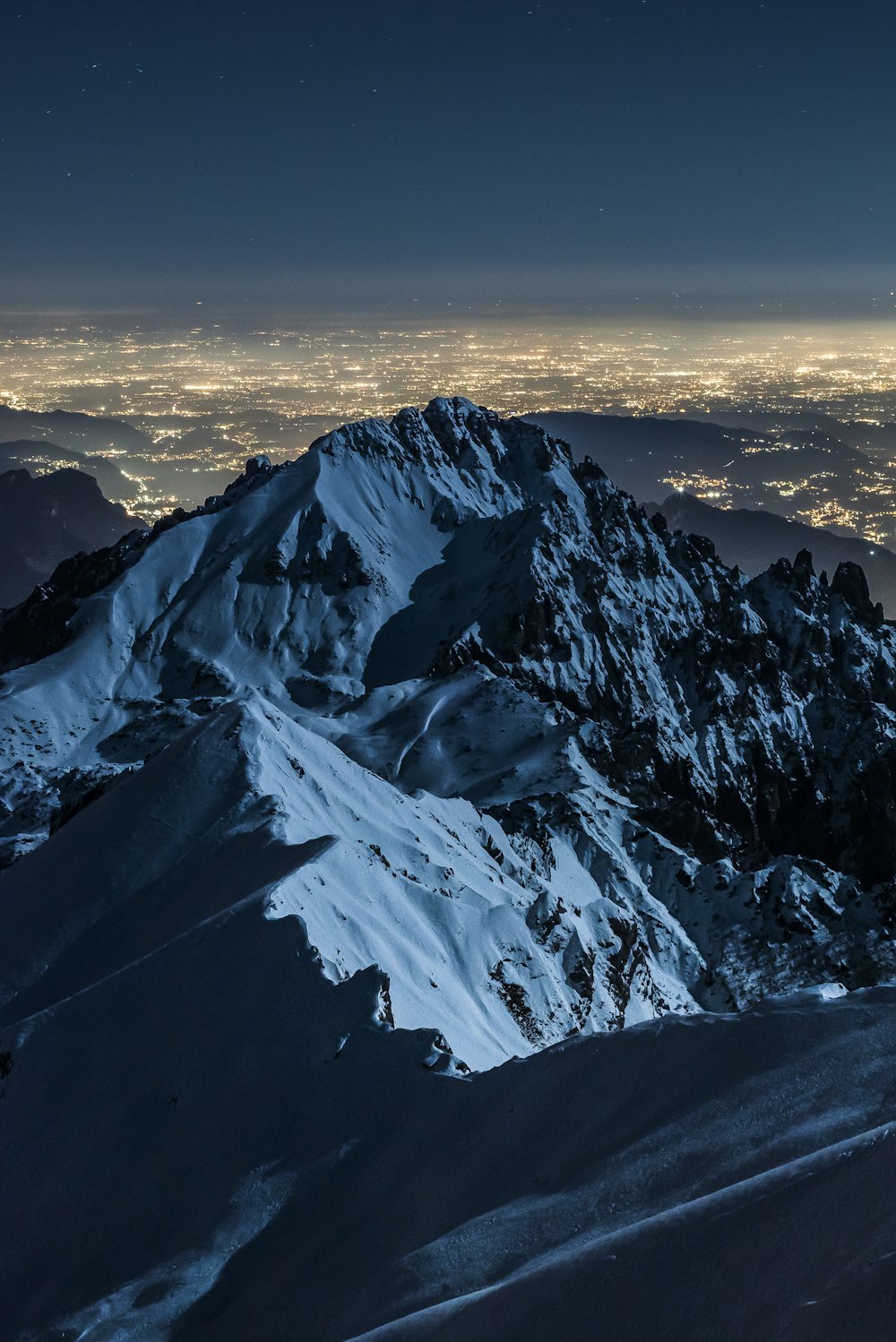 Fotografía de paisajes de campo y montaña cubiertos de nieve durante la noche