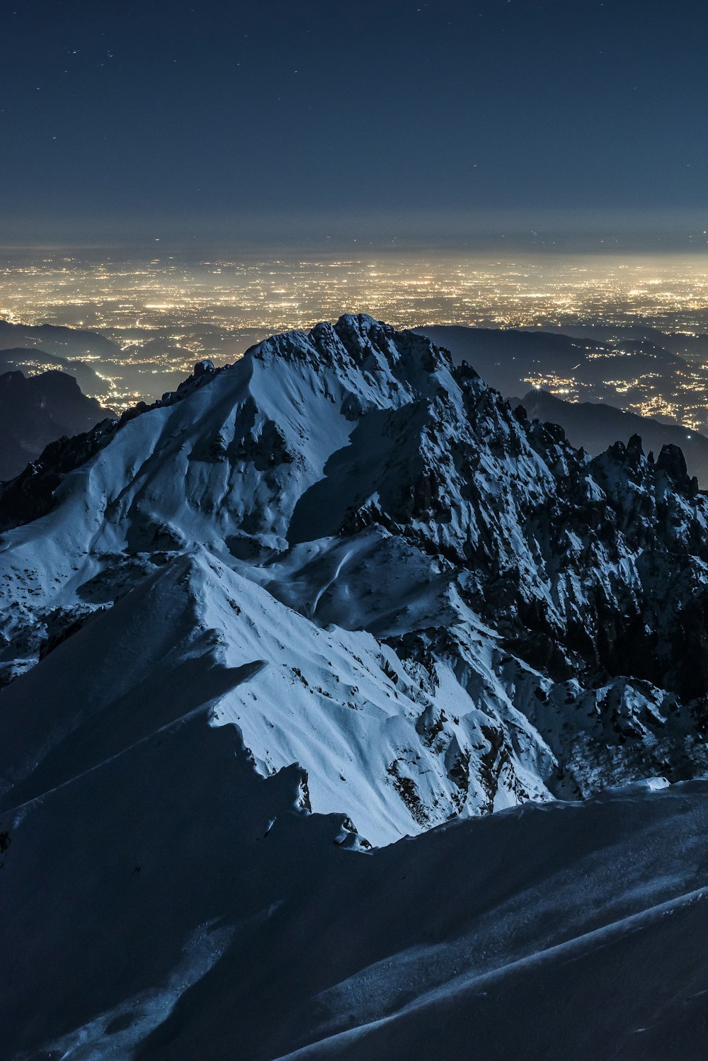 fotografia de paisagem do campo e da montanha coberta de neve durante a noite