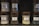 Several glass jar candles with wooden lids are displayed on shelves. The candles have labels with different scents including White Honey, Oudwood, Vanilla Bean, and Evening Bonfire.