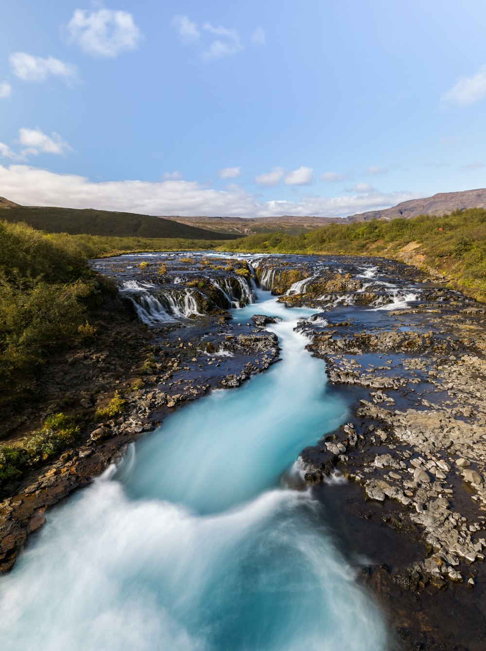 time-lapse photography of river at daytime by hills