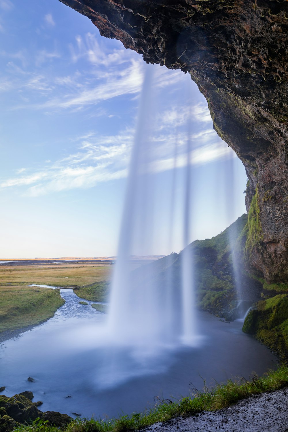 waterfalls viewing green field under blue and white sky