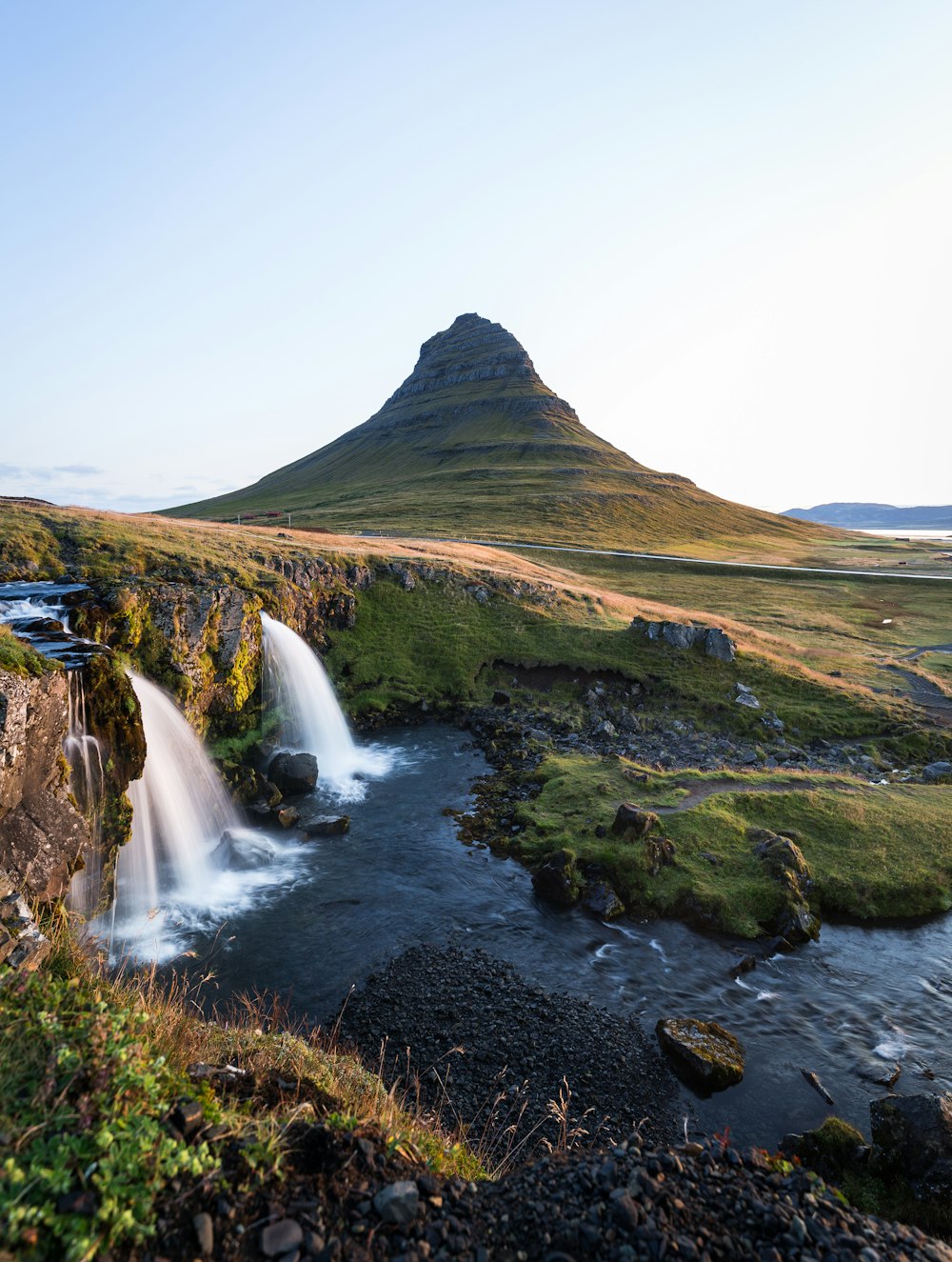 landscape photography of waterfalls viewing mountain and green field during daytime
