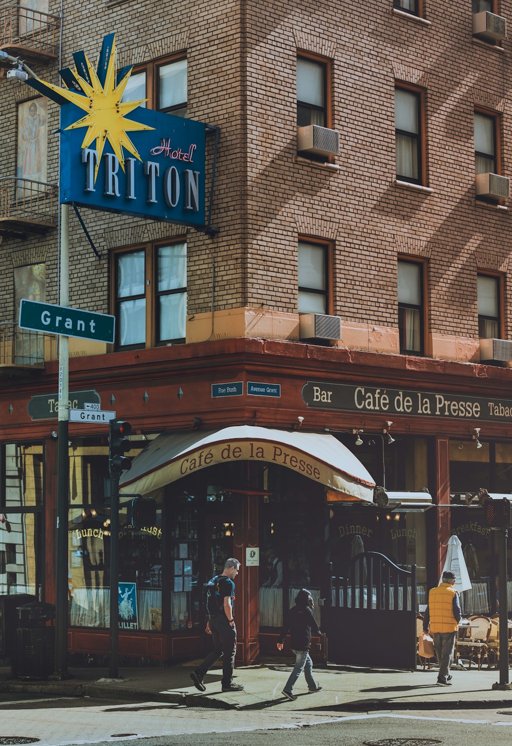 few people walking on street near Triton Hotel during daytime