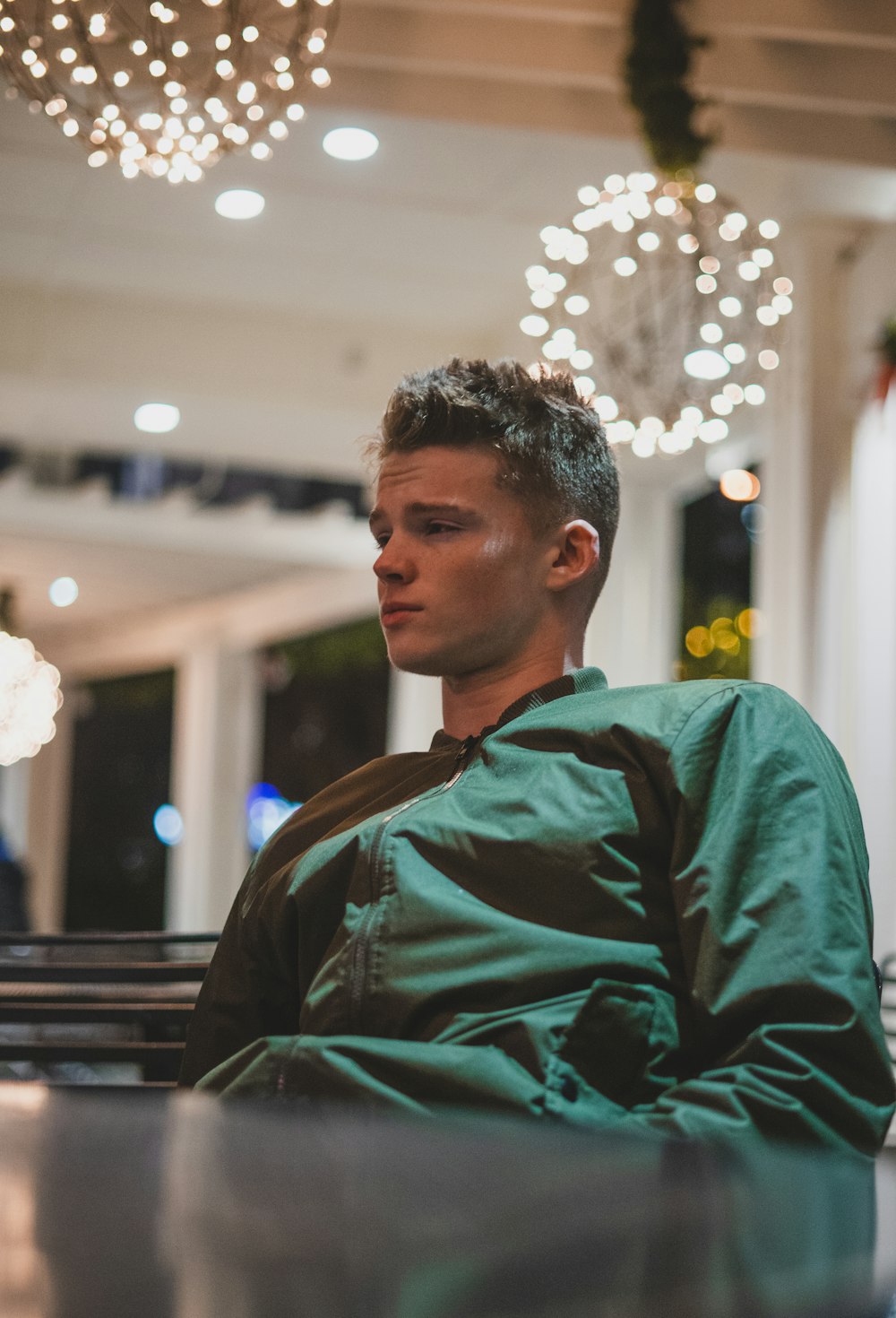 man wearing green zip-up jacket sitting