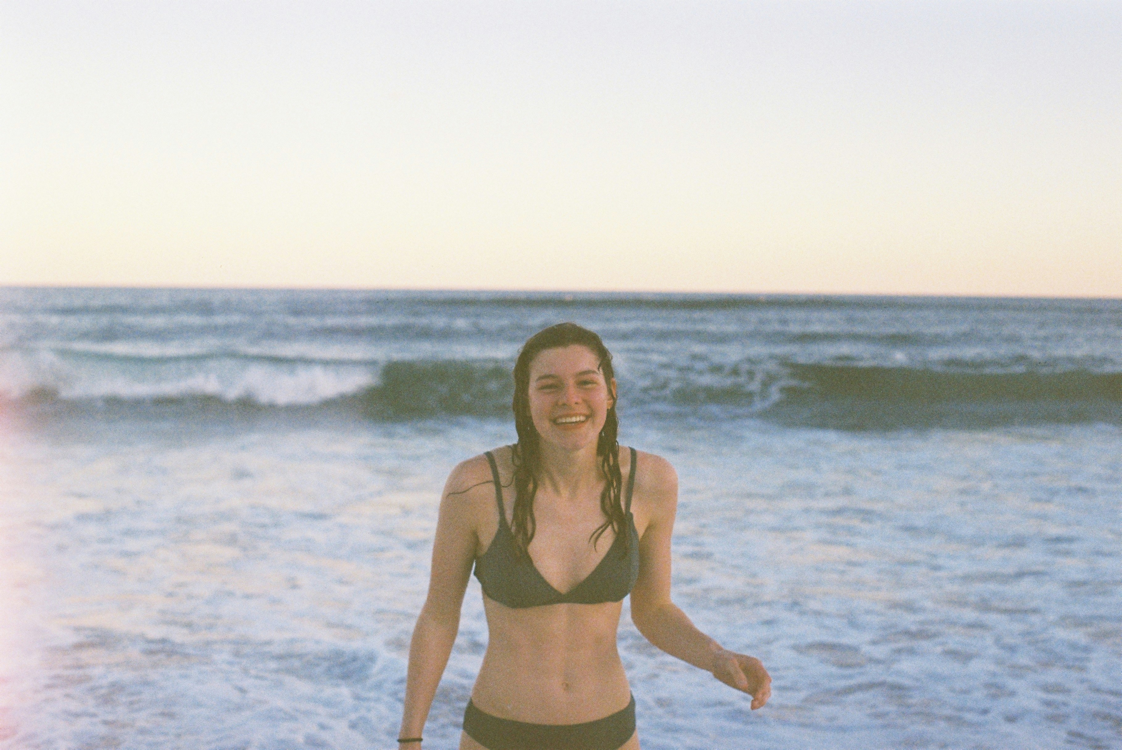 woman in black bikini standing in seashore
