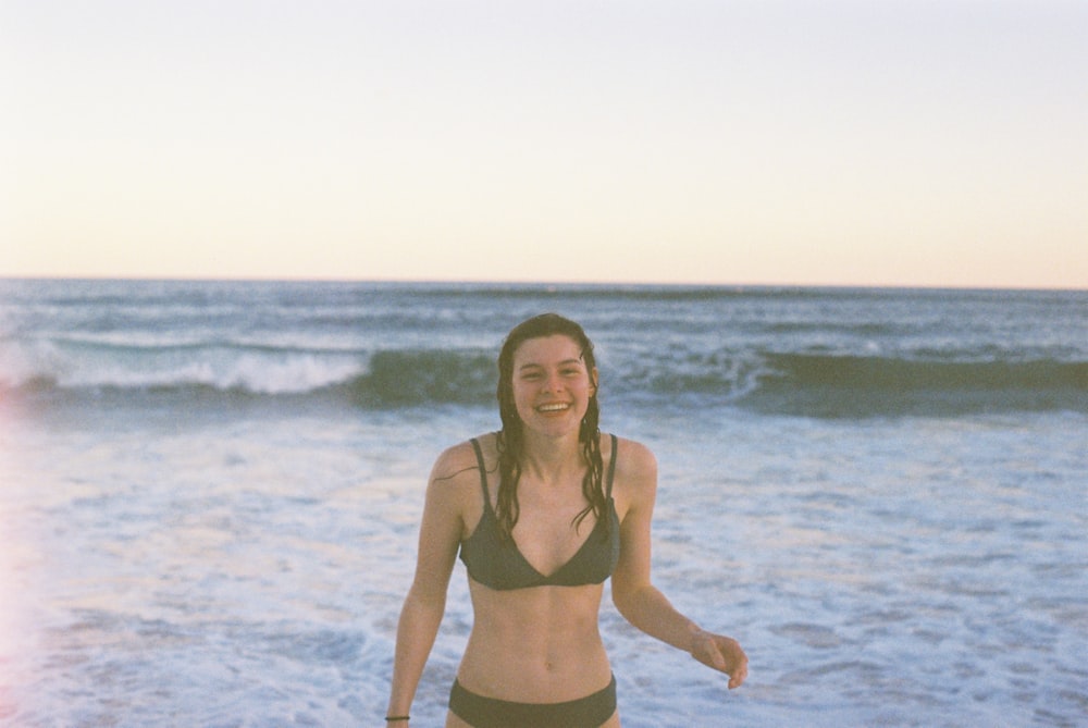 woman in black bikini standing in seashore