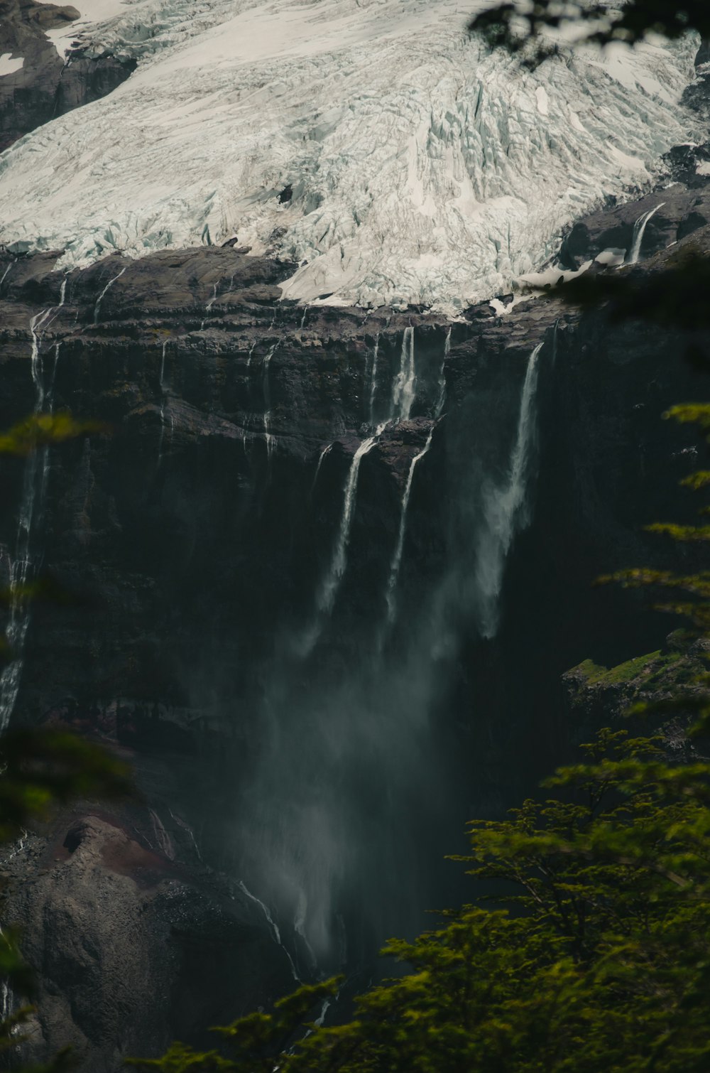 waterfalls near green trees during daytime