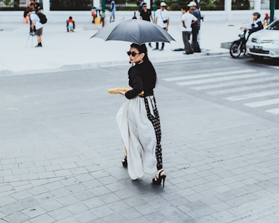 A stylish woman carrying a Ventriz handbag while walking through a sunny city street.
