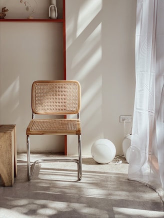 brown and gray armless chair beside window
