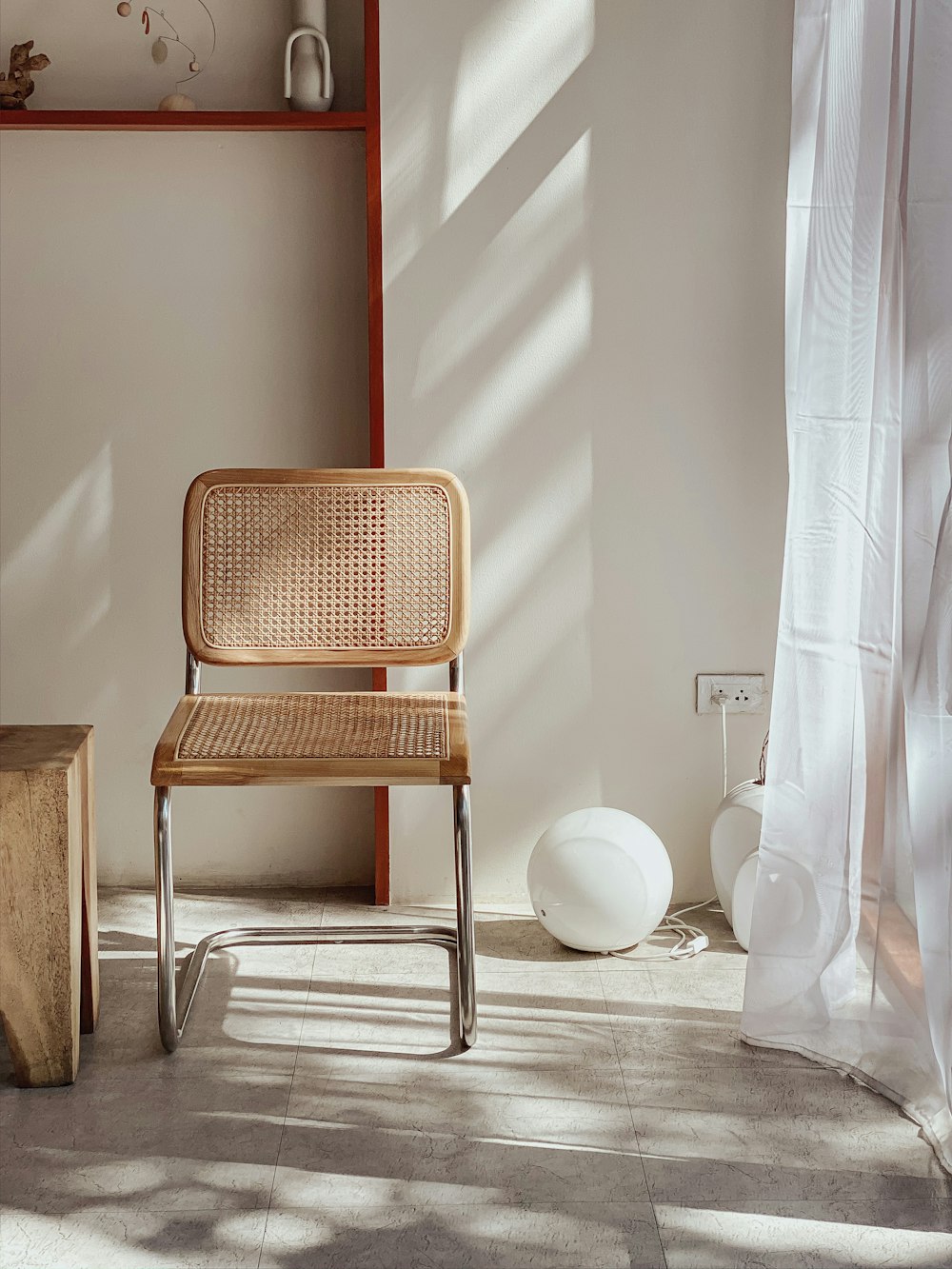 brown and gray armless chair beside window