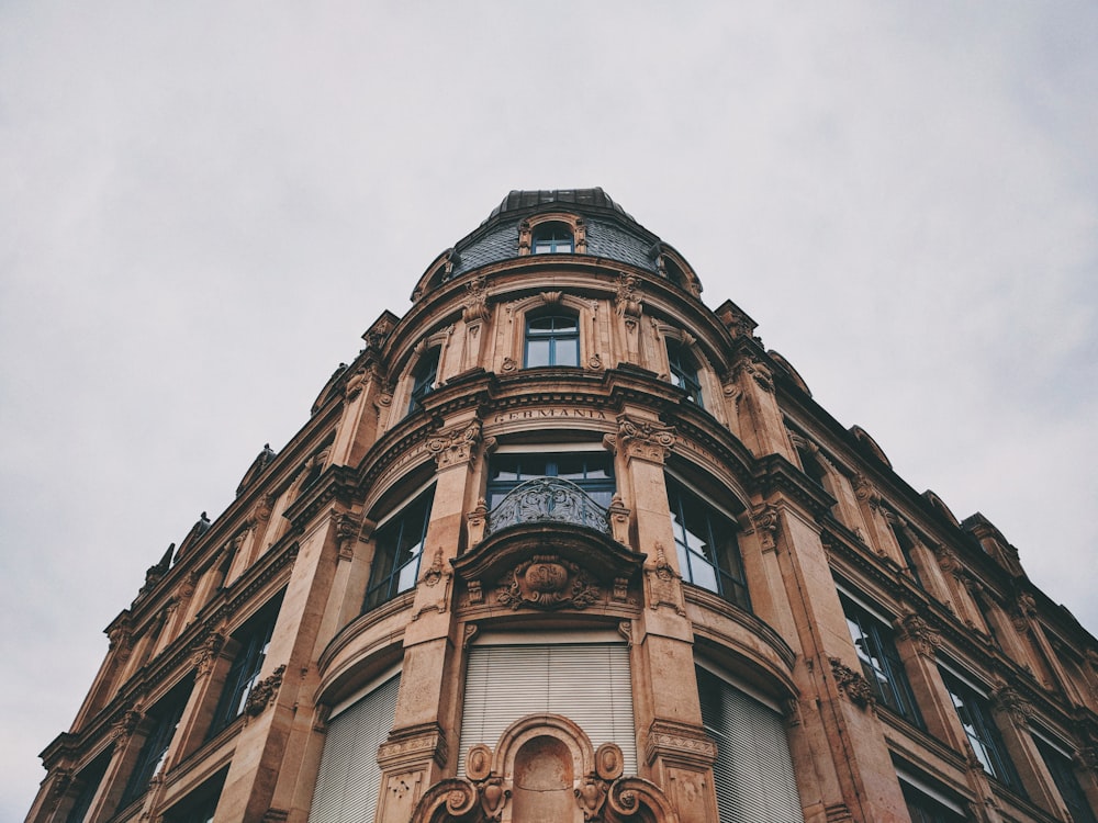 Fotografía de ángulo bajo de un edificio de hormigón marrón durante el día