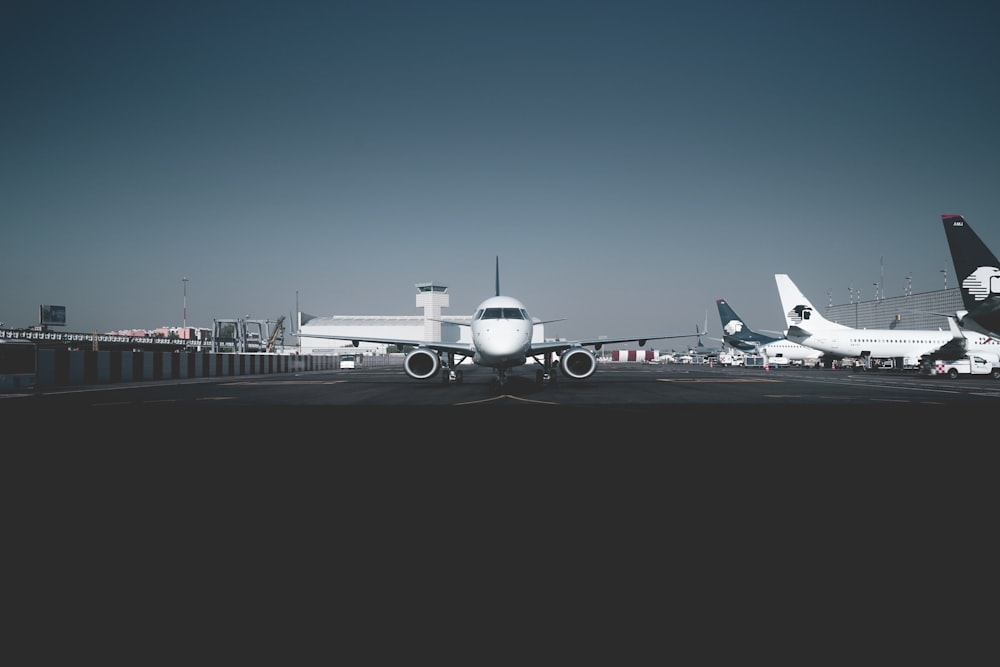 white passenger airplanes on railway during daytime