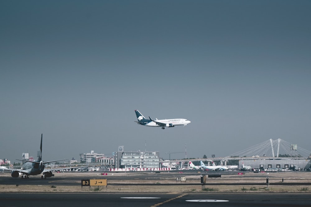 flying white and blue airliner plane during daytime