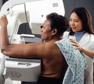 female doctor standing near woman patient doing breast cancer screening