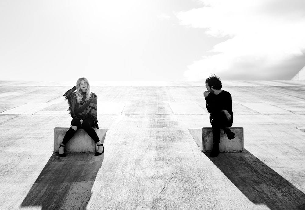 two person sitting on the box greyscale photograph