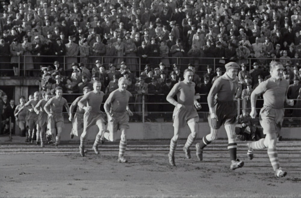 grupo de personas corriendo en el campo de fútbol