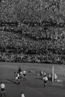 Iconic shot of a famous football player scoring a decisive goal in a packed stadium