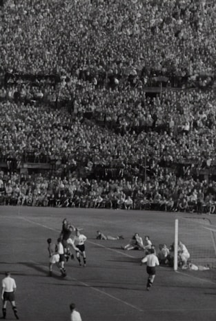A vintage football match in black and white, capturing the passion of early soccer days.