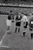 two person doing shake hands on a soccer game greyscale photograph