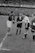 A confident young football player shaking hands with an agent on a sunny stadium field.