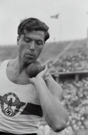 Black and white photo of a focused male student-athlete training intensely in a modern gym.