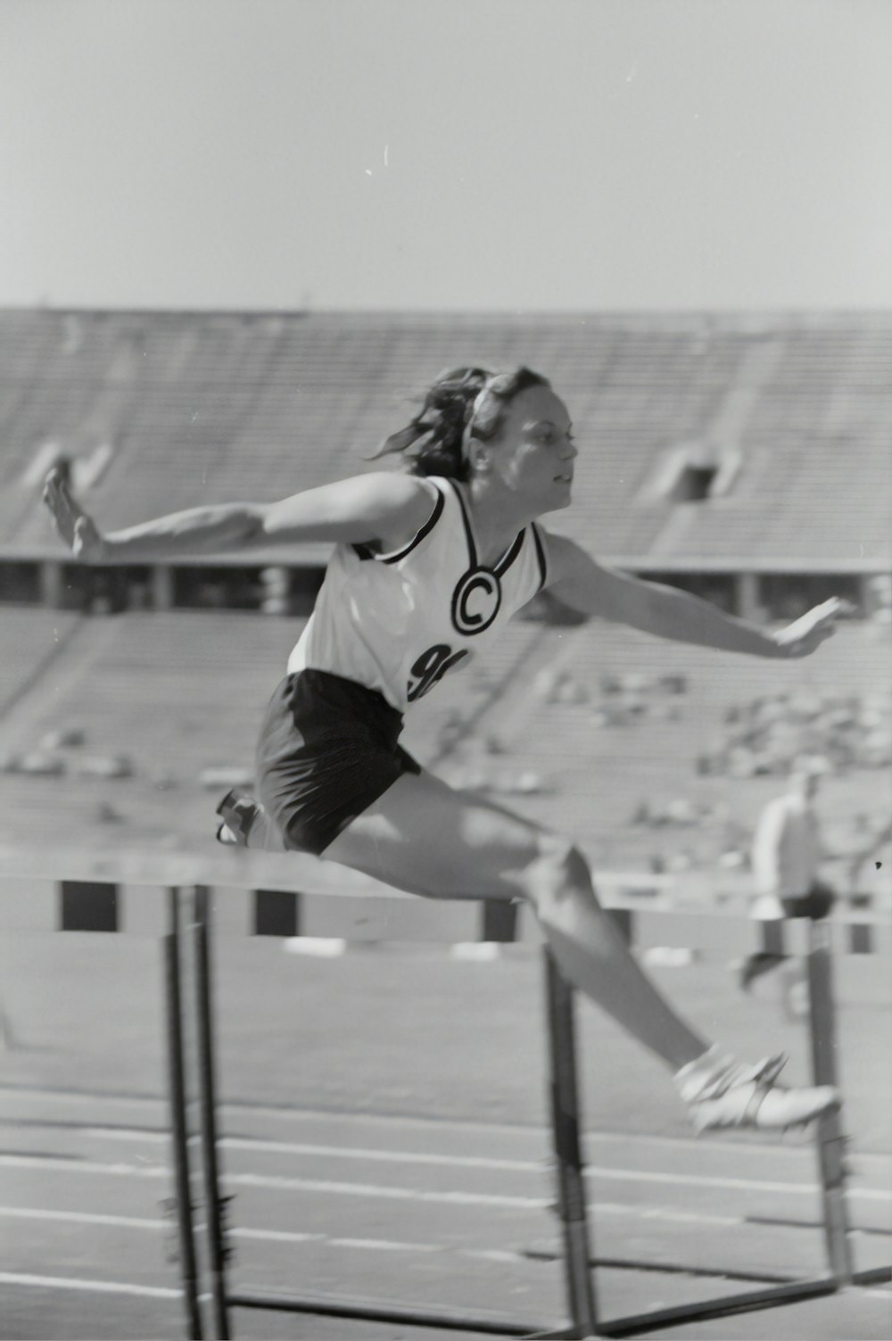 grayscale photography of woman doing hurdle