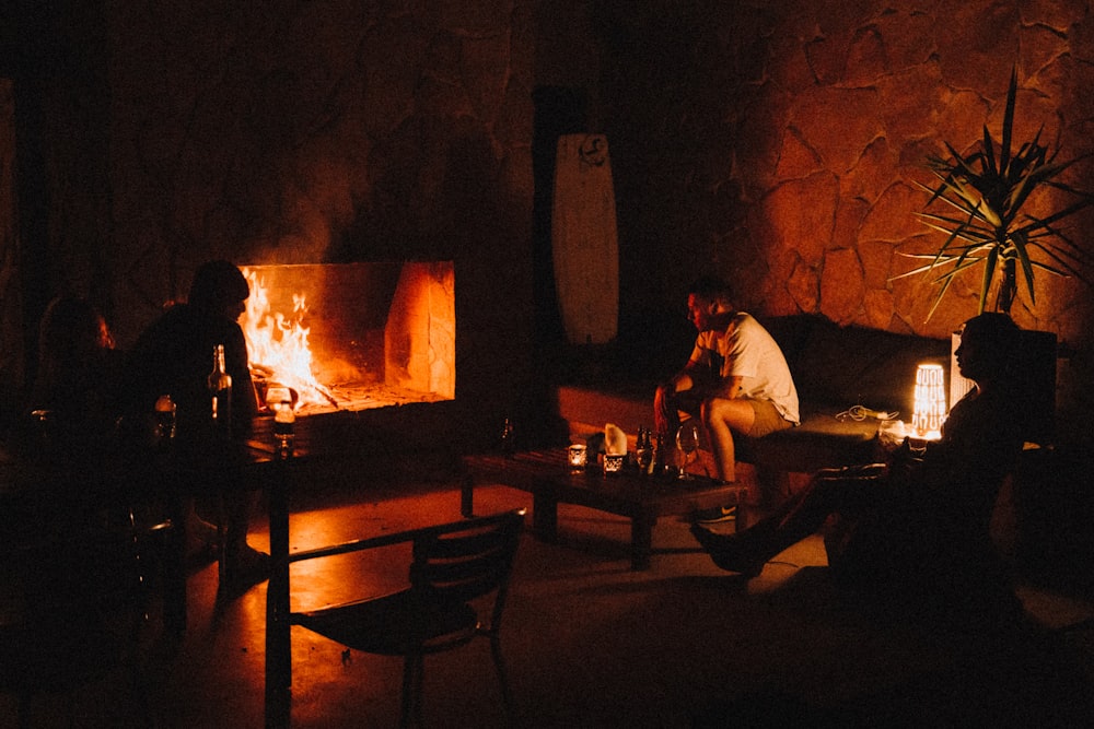 several people sitting beside fireplace