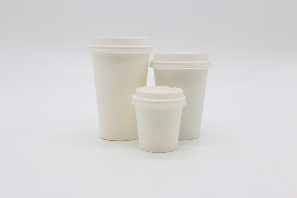 three white disposable cups