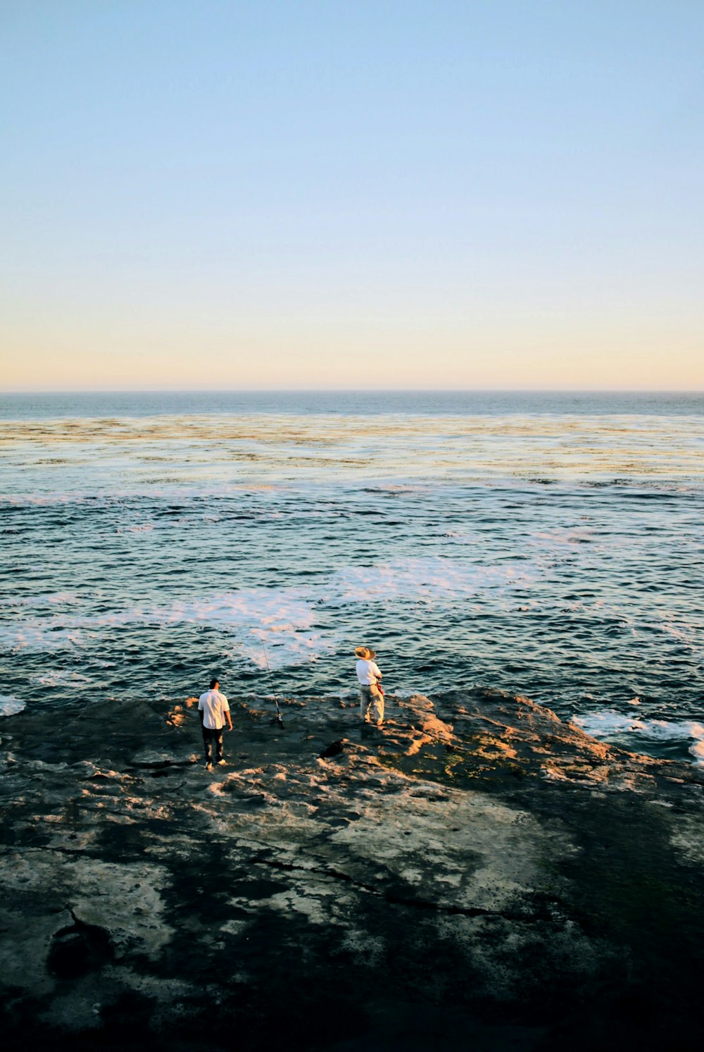 two person standing in front of shoreline