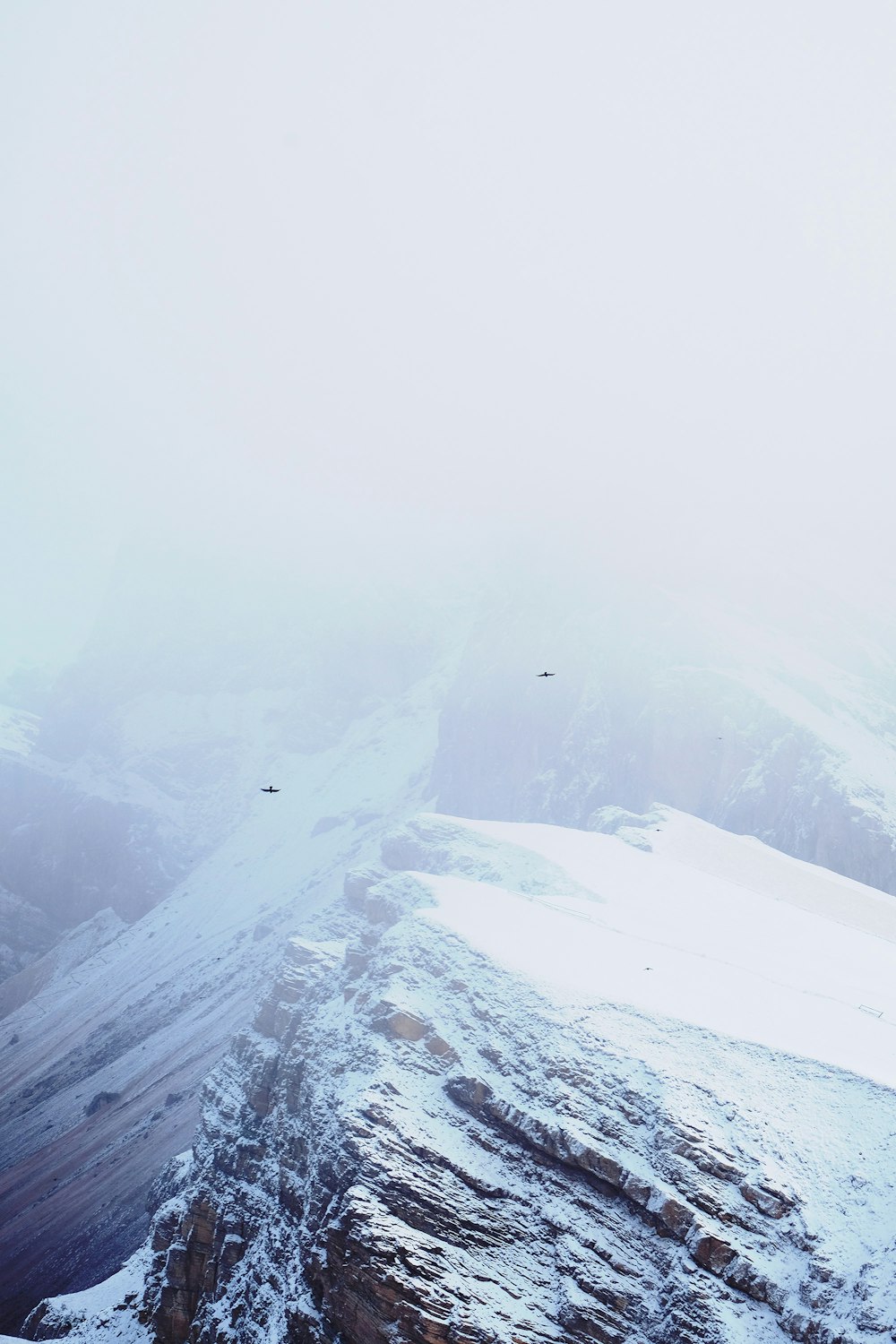 mountain covered with snow and fogs